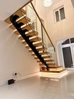 Escalier sur mesure Prima, style minimaliste, avec rampes en verre sans cadre, conçu pour les maisons à concept ouvert et les espaces de vie modernes