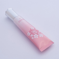 Sérum pour les yeux rose nacré dégradé en tube avec applicateur à pointe de massage en métal argenté 40 ml