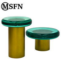 Table console moderne pour salons, avec plateau en acrylique translucide vert et base en acier inoxydable doré.