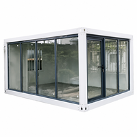 Module de maison conteneurisée détachable à structure blanche et entièrement vitrée avec coins renforcés pour utilisation en showroom d'exposition dans les places urbaines modernes