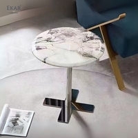 Table d'appoint ronde minimaliste, surface aspect pierre veinée blanche, base croisée pour salon