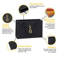 Sac de beauté vertical en papier spécial lin fin noir avec monogramme, logo SSM superposé en serif doré et poignée en cordon tressé