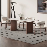 Table à manger de style scandinave avec plateau blanc mat et base en bois massif pour un mobilier de salle à manger minimaliste de style Japandi.