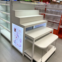 Étagères de présentation pour supermarchés, système de rayonnage métallique LED pour magasins de maquillage et cosmétiques, étagères blanches à niveaux avec embouts.