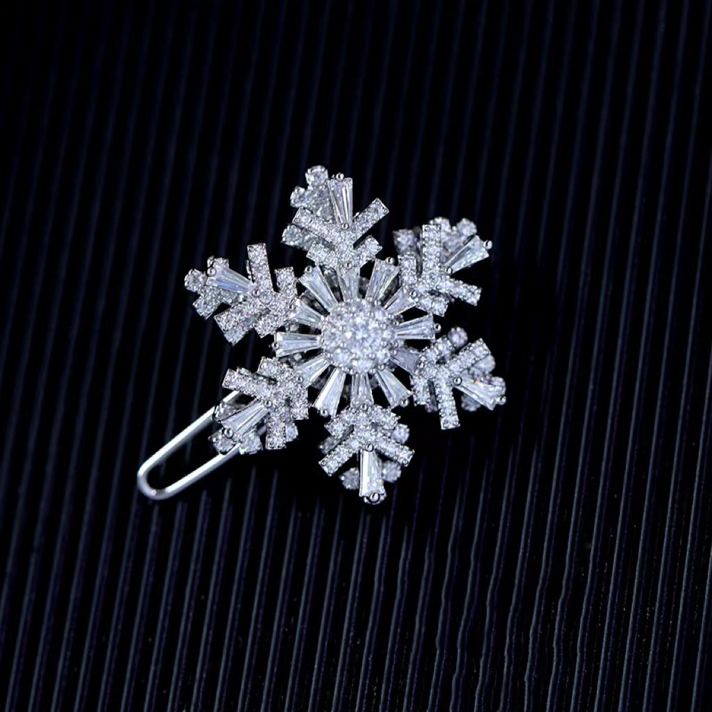 Pinza para el cabello con forma de copo de nieve plateado.