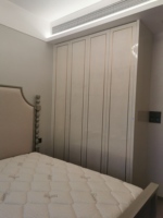 Armoire de chambre d'angle en L personnalisée, finition brillante, en composite, avec miroir, modulaire et symétrique, pour chambre à coucher