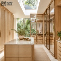 Dressing en rotin tressé de style côtier australien avec portes en verre transparent et îlot en pierre calcaire pour suite parentale