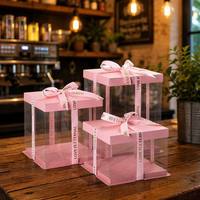 Boîte à gâteau avec couvercle en papier rose, base rose et panneaux latéraux transparents. Matériel de qualité alimentaire, écologique, sans ruban