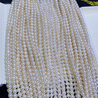 Perles de culture d'eau douce blanches naturelles en gros près de perles d'eau douce naturelles en vrac rondes