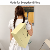 Sacs cadeaux personnalisés en papier cartonné blanc pour lancement de collections de vêtements et événements promotionnels – Emballage shopping personnalisé avec logo pour la vente au détail