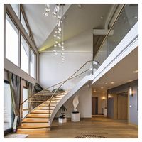 Escalier courbe contemporain avec marches en bois pour les maisons familiales modernes, alliant chaleur et lignes épurées pour les unités duplex de luxe