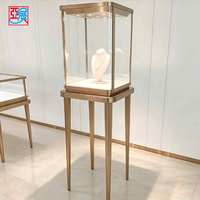 Présentoir à bijoux en verre avec cadre doré élégant et personnalisable, éclairé par LED, pour magasin de bijoux