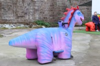 Trottinette électrique dinosaure violette pour enfants, siège lumineux et sûr, idéale pour les parcs de jeux et la location extérieure