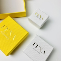 Boîte cadeau pour bijoux A1 gaufrée blanche avec zone de texte dorée, sac jaune et surface tactile pour la remise aux clients de marques de boutiques