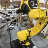 Robot FANUC M-20iD/25, 25 kg, 1831 mm, pour préhension et placement d'objets métalliques avec préhenseur personnalisé dans une clôture de sécurité, PLC intégré