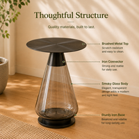 Table d'appoint ronde moderne et écologique avec plateau en acier inoxydable noir et base conique transparente fumée pour salon
