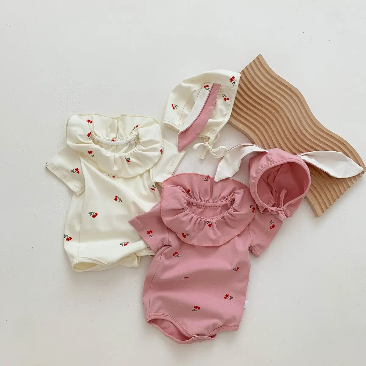 جمبسوت أطفال وحديثي الولادة بتصميم لطيف مصنوع من قماش الكرز بأكمام قصيرة وكشكشة مع قبعة على شكل أذن أرنب موديل 2024