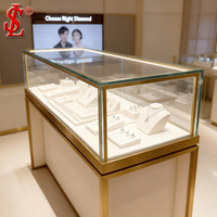 Vitrine de présentation de bijoux de luxe en verre doré, cadre en or brossé, éclairage LED, meuble de vente au détail, aménagement de boutique