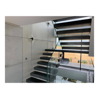 Escalier flottant cantilever avec supports muraux simples, marches en chêne blanc, main courante en métal noir, escalier au design moderne