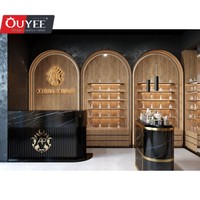 Comptoir présentoir de parfums en marbre au design d'intérieur Parfumerie unique Vitrine murale arquée en placage de bois pour parfumerie avec lumière LED