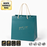 Sacs cadeaux en papier bleu sarcelle avec logo personnalisé KM, poignée en corde de coton crème, cœur en feuille d'or, pour boutique et vente au détail