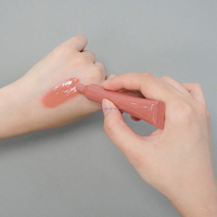 Gloss à lèvres teinté hydratant et repulpant aux herbes et minéraux, infusé de peptides et pailleté
