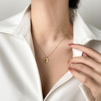 Collier ras du cou en acier titane plaqué or avec pendentif rond au design artistique et motif émaillé