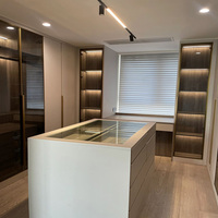 Dressing moderne sur mesure autoportant avec étagères ouvertes spacieuses, éclairage LED et îlot de présentation de bijoux pour villa