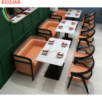Ensemble de banquettes et de chaises de restaurant avec revêtement orange, cadres noirs et tables à manger blanches