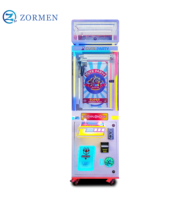 Zormen Máquina de grúa de una sola garra mini con diseño de mapache, gabinete luminoso, operada con monedas, juego de venta sorpresa para fiestas