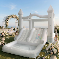 Structure gonflable commerciale blanche pour mariage, avec toboggan double piste et piscine à balles, idéale pour les fêtes de mariage en extérieur sur pelouse