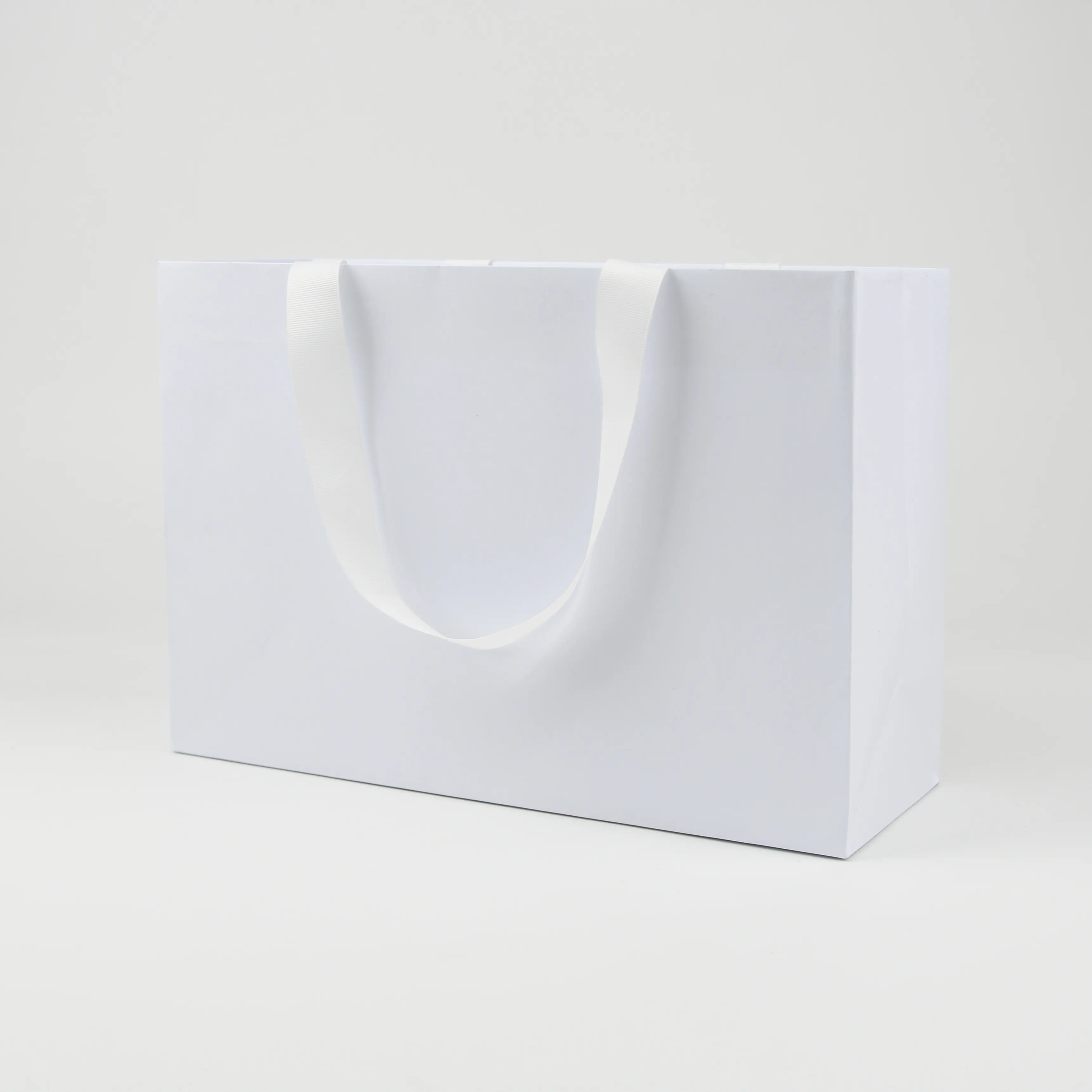 Wholesale custom printed white luxury shopping gift paper bag with handle and bow ,luxury paper bags with your own logo