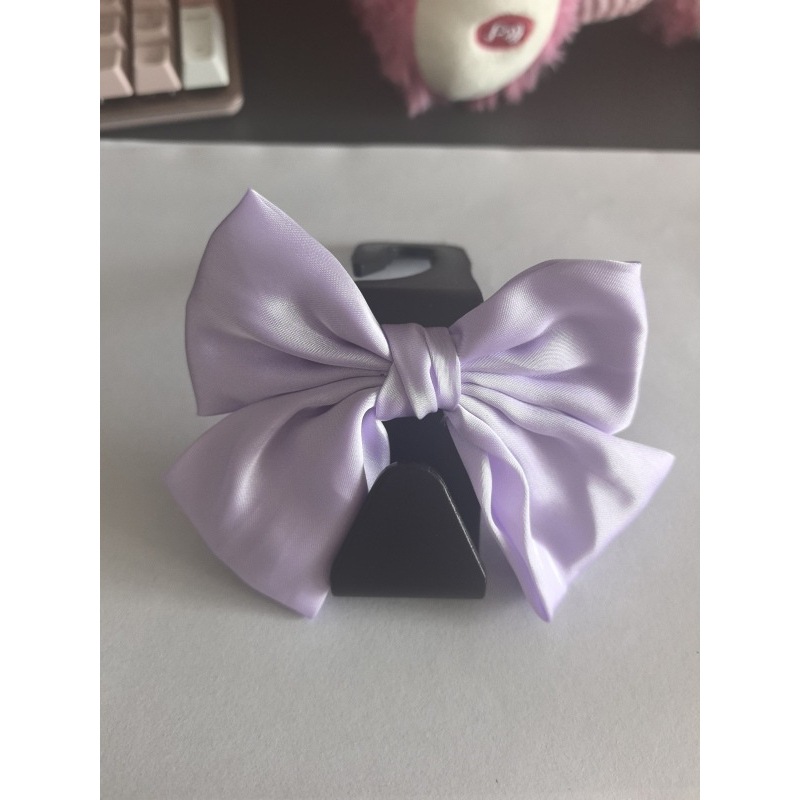 Crochet noir en forme de 7 avec nœud violet attaché