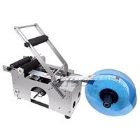 Petite machine d'étiquetage adhésif semi-automatique de bureau pour bouteilles d'eau rondes en plastique PET, canettes et bocaux
