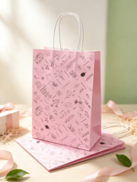 Sac en papier rose à motifs floraux et de papeterie, idéal pour les cadeaux et les faveurs de mariage