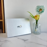 Scatola Minimalista in Carta Argentata con Logo Sorriso per Packaging da Viaggio: Dove Ogni Viaggio Incontra un Sorriso Gioioso, Creando un Rituale di Viaggio