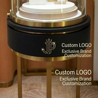Vitrine à bijoux ronde en acier inoxydable brossé or de luxe avec verre incurvé sans joint à 45 degrés pour boutique de marque haut de gamme