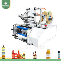 2025 Precio bajo Pequeña empresa Fábrica Manual Contenedor semiautomático Máquina de etiquetado de botellas redondas
