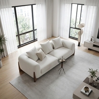 Canapé élégant en tissu blanc avec pieds en bois, canapé moderne et spacieux pour salon lumineux avec grandes fenêtres