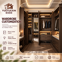 Dressing sur mesure en bois de noyer foncé avec miroir central et étagères éclairées par LED pour vestiaires de villas de luxe