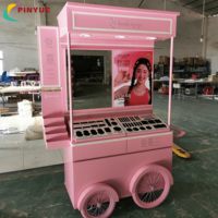 Chariot de présentation mobile haut de gamme rose personnalisé pour cosmétiques et parfums, avec auvent et roues, idéal pour les événements en centre commercial