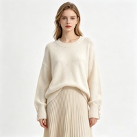 Pull en maille doux effet cachemire pour femme, col rond, manches longues, poignets boutonnés, coupe ample et oversize, idéal automne-hiver