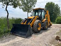 Chargeuse-pelleteuse JCB 4CX, moteur jaune, carrosserie noire, cabine avec intérieur rouge, siège rouge