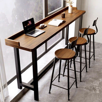 Tables de bar modernes en bois massif, tables longues près de la fenêtre, tables hautes et chaises étroites contre le mur