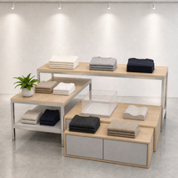 Ensemble de table de présentation à niveaux en MDF et acier inoxydable avec pieds fins noirs et armoire grise sur mesure