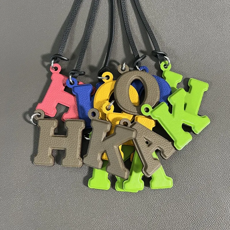 Colgante de bolsa de color personalizado, material de cuero genuino, colgante de llave de coche con letras tridimensionales