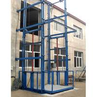 Plateforme élévatrice verticale hydraulique 5000 kg à double rail de guidage pour installation extérieure avec enceinte de sécurité en treillis métallique