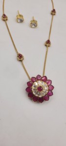 Ensemble de pendentifs fleuris plaqués or rubis, comprenant un pendentif floral central avec des pierres rouges et des accents blancs, et une chaîne délicate. - Product Image 2