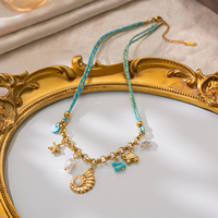 Collier de style côtier en acier inoxydable plaqué or PVD 18 carats avec breloque en corde tressée, coquillage, étoile de mer, perle et turquoise – Bijoux de plage
