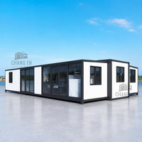 Conteneur préfabriqué extensible de luxe JHCE de 40 pieds, structure en acier noir, design moderne avec fenêtres latérales, hôtel, villa